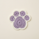 Purple and white crochet pawprint coaster - front view