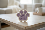 Purple and white crochet pawprint coaster - lifestyle shot