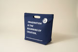 Imagination Tote - Angled view on navy canvas tote bag